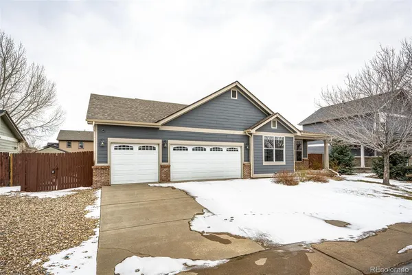 a front view of a house with a yard covered in snow