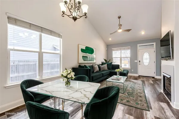a living room with furniture a chandelier and a flat screen tv
