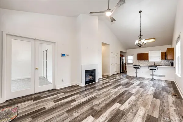 a view of a livingroom with a fireplace a flat screen tv and a wooden floor