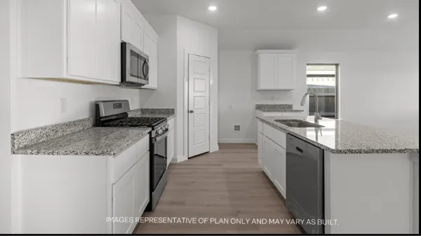 a kitchen with stainless steel appliances granite countertop a stove a sink and a microwave