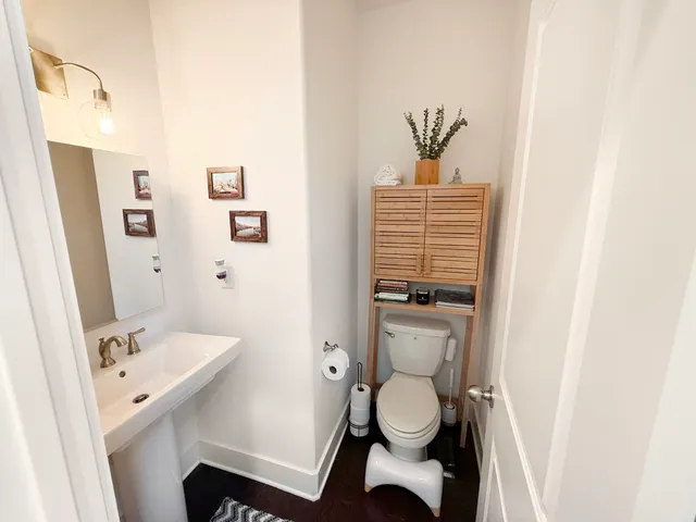 a bathroom with a toilet sink and mirror
