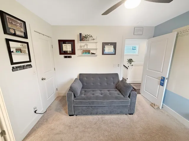 a living room with furniture and a refrigerator
