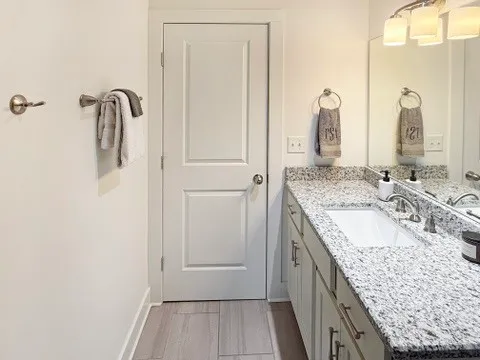a bathroom with a granite countertop toilet sink and mirror