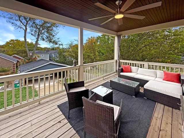 a balcony with wooden floor and outdoor seating