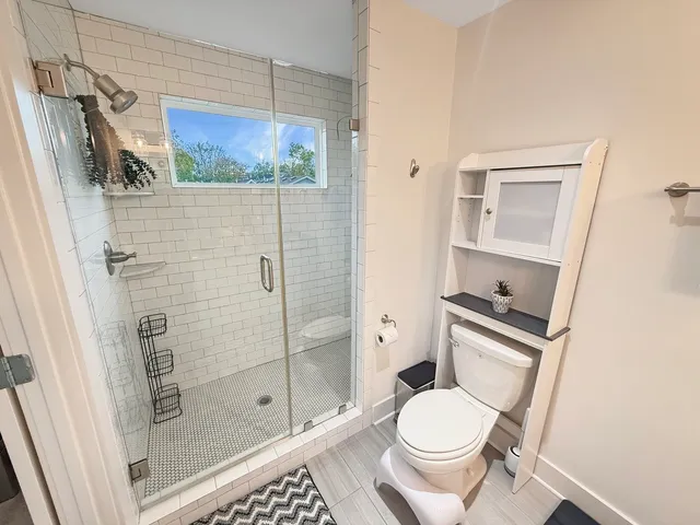 a bathroom with a granite countertop toilet sink and mirror