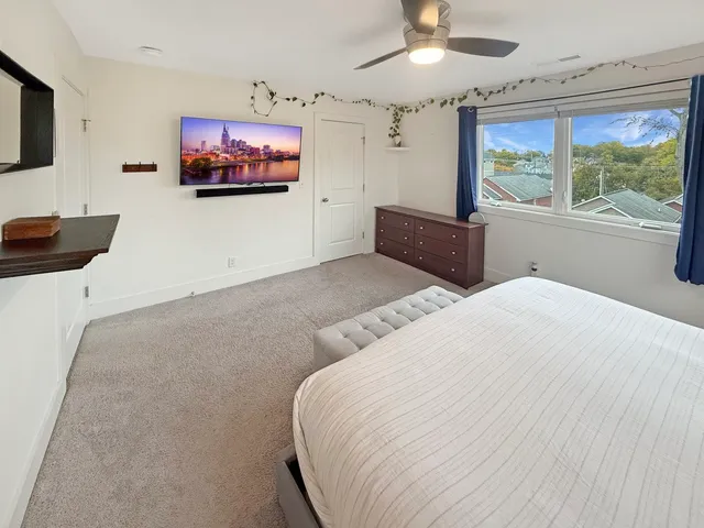 a bedroom with a bed and a painting on the wall