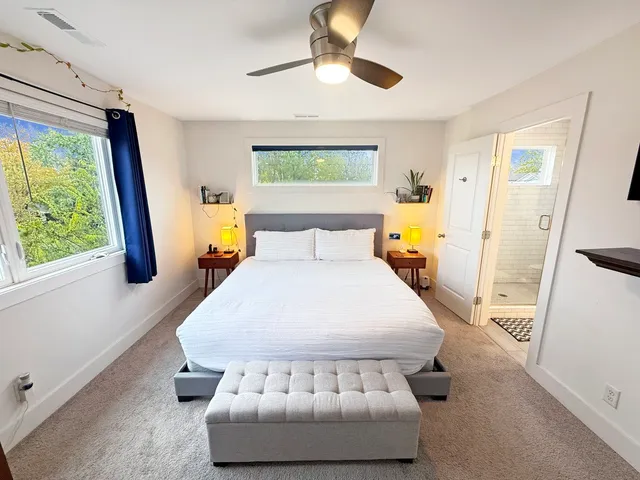 a bedroom with a large bed and a flat tv screen on dresser