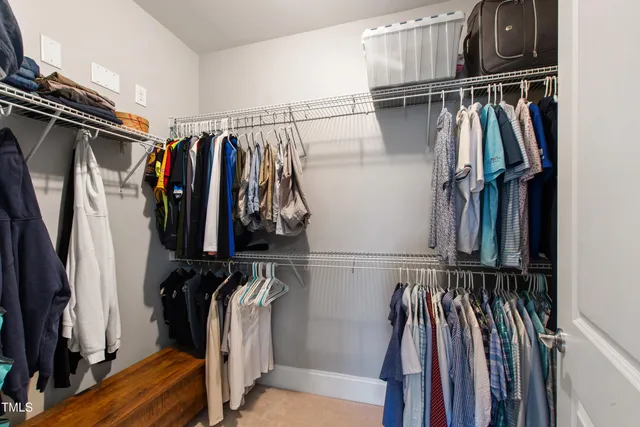 a view of walk in closet with clothes and shoes