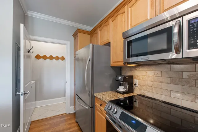 a kitchen with stainless steel appliances granite countertop a refrigerator and a stove