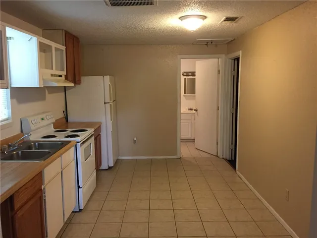 a kitchen with a stove cabinets and a refrigerator