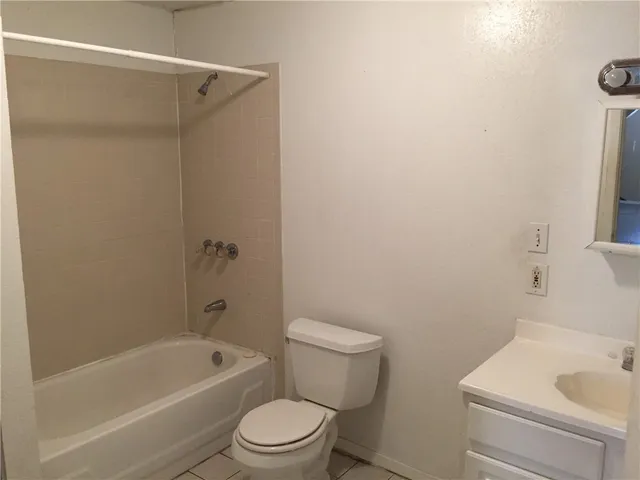 a white toilet sitting next to a bath tub