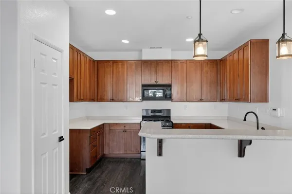 a kitchen with stainless steel appliances granite countertop a sink a stove and a refrigerator