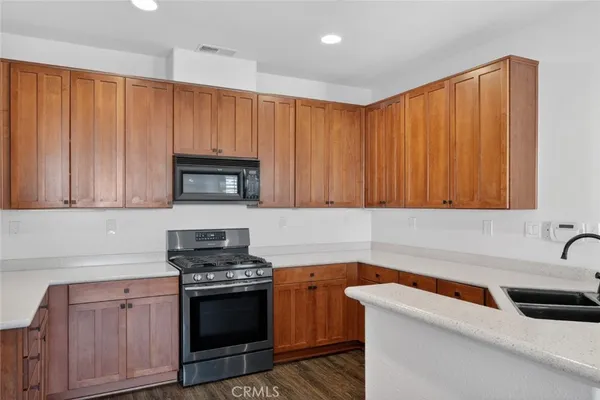 a kitchen with granite countertop a sink stainless steel appliances and cabinets