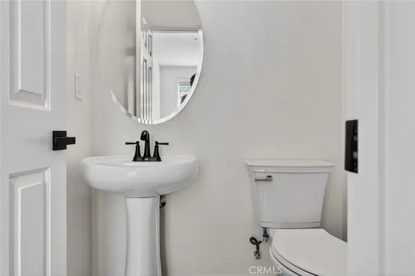 a bathroom with a toilet a sink and mirror