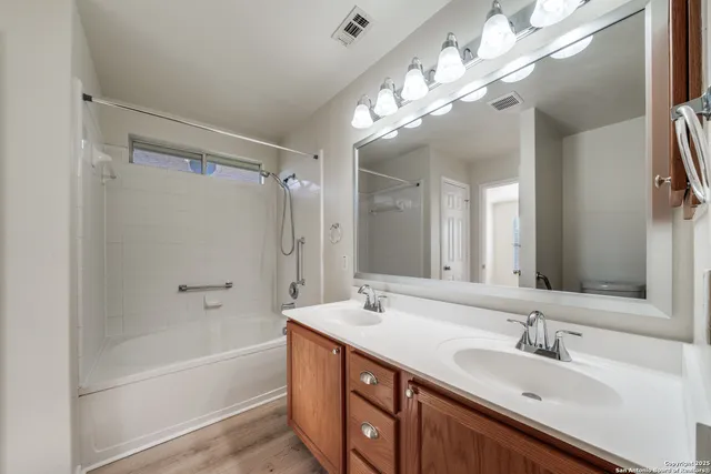 a bathroom with a double vanity sink a large mirror and shower