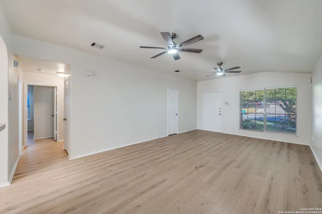 a view of empty room with wooden floor