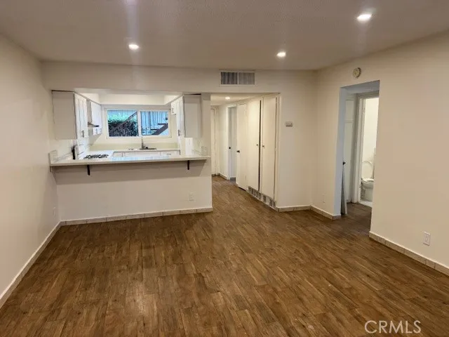 a view of kitchen with wooden floor and electronic appliances