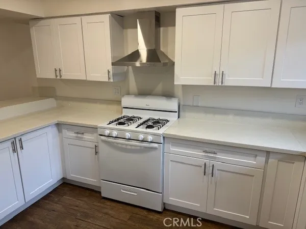 a kitchen with white cabinets and white appliances