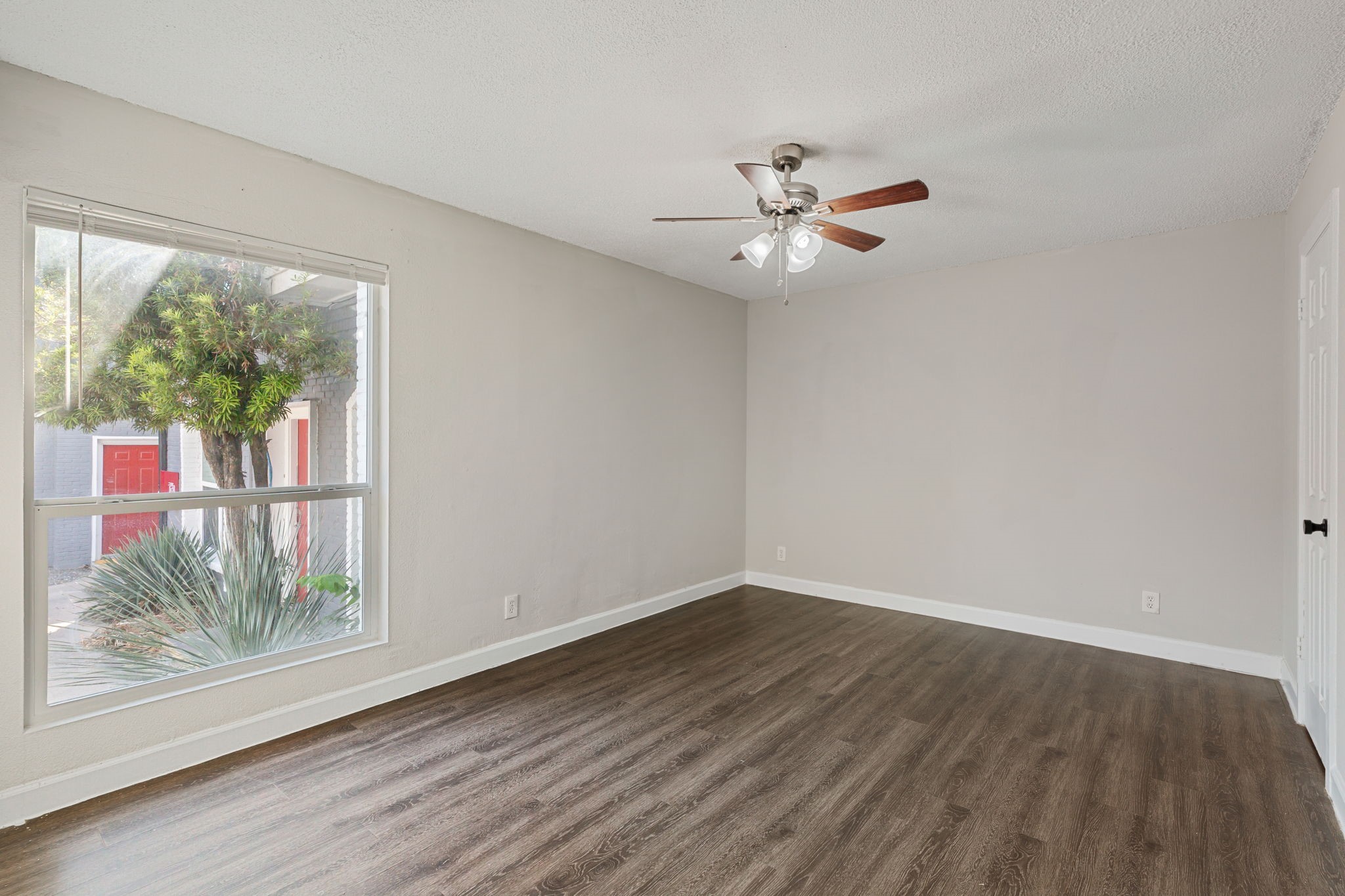5005 Manor Road, Unit 132 Austin, TX 78723 - Photo 11 of 28 a view of an empty room with wooden floor and a window