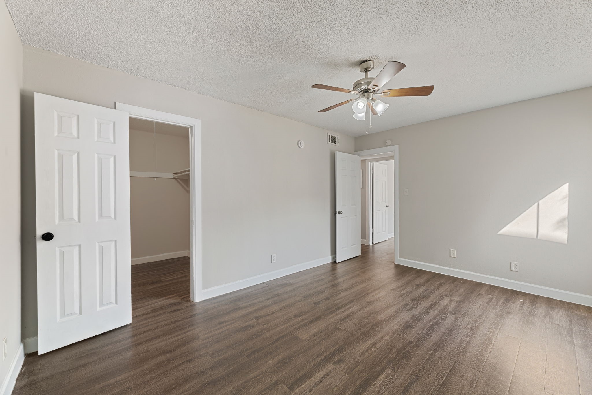 5005 Manor Road, Unit 132 Austin, TX 78723 - Photo 13 of 28 an empty room with wooden floor ceiling fan and window