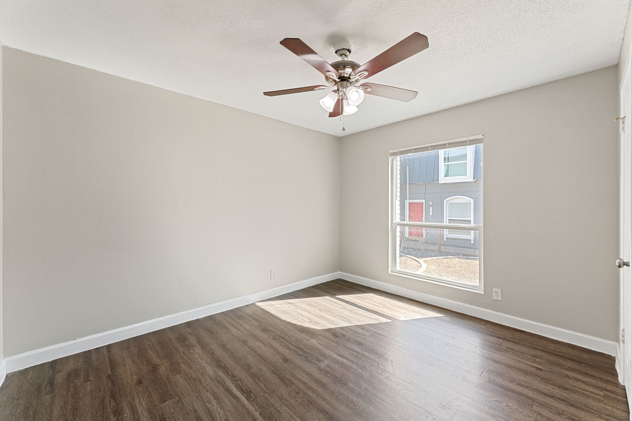 5005 Manor Road, Unit 132 Austin, TX 78723 - Photo 15 of 28 an empty room with wooden floor fan and windows