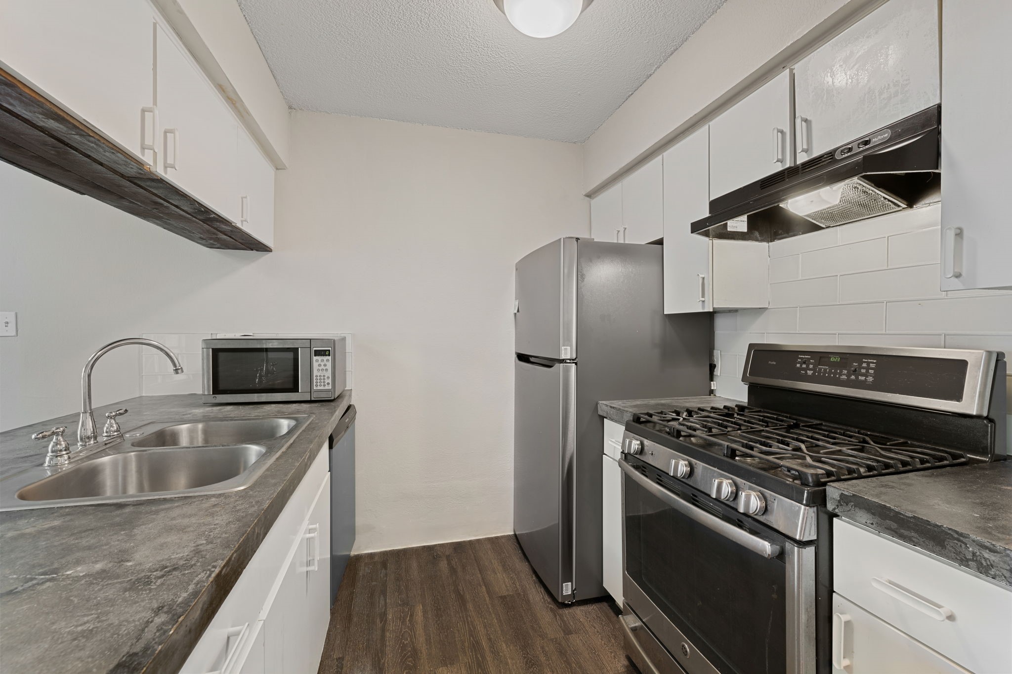 5005 Manor Road, Unit 132 Austin, TX 78723 - Photo 2 of 28 a kitchen with granite countertop a sink stove and refrigerator