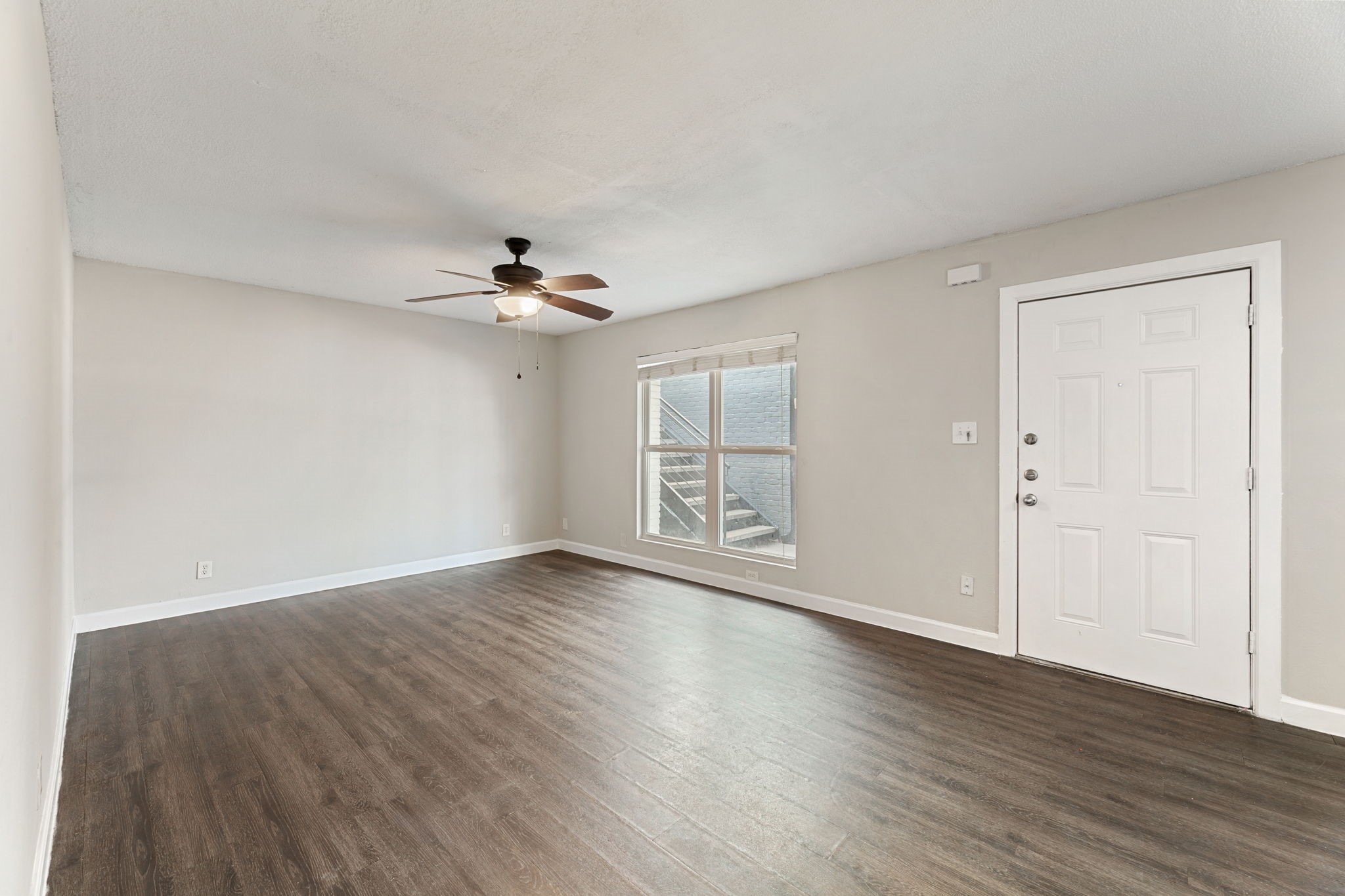 5005 Manor Road, Unit 132 Austin, TX 78723 - Photo 22 of 28 a view of an empty room with wooden floor and a ceiling fan