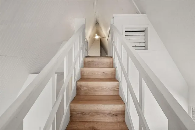 a view of staircase with lots of frames on wall and windows