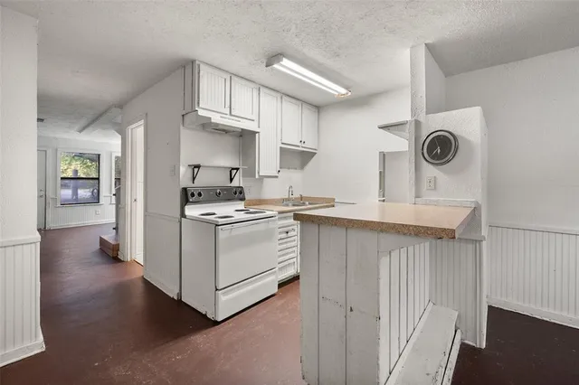 a kitchen with cabinets and wooden floor