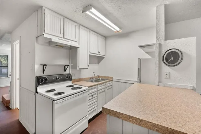 a kitchen with stainless steel appliances granite countertop a sink a stove and a refrigerator