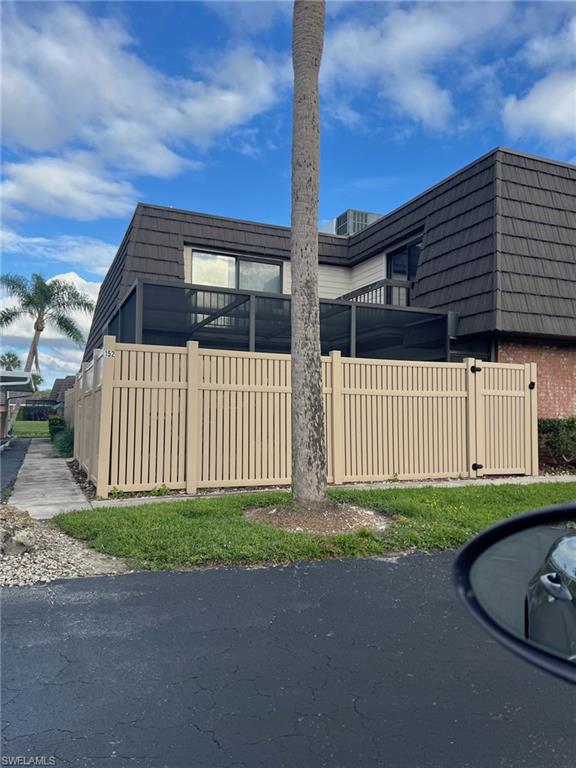 152 Lake Point Lane, Unit 4A Naples, FL 34112 - Photo 2 of 15 a view of a house with a small yard and wooden fence