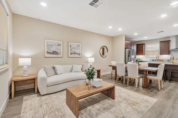 a living room with lots of furniture and view of kitchen