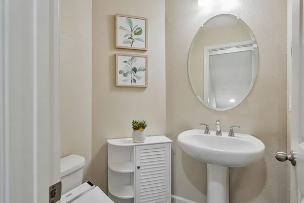 a bathroom with a sink mirror and toilet