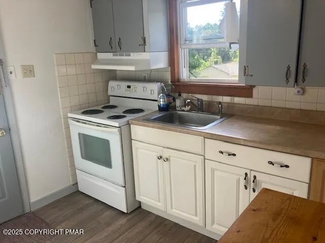 a white kitchen with sink a window and appliances