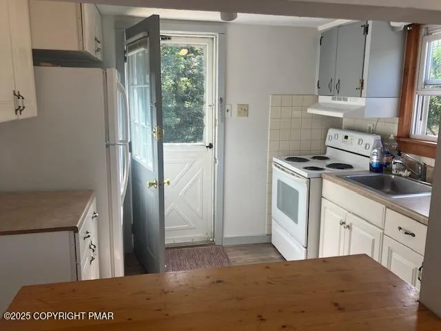 a kitchen with a stove a refrigerator and a sink