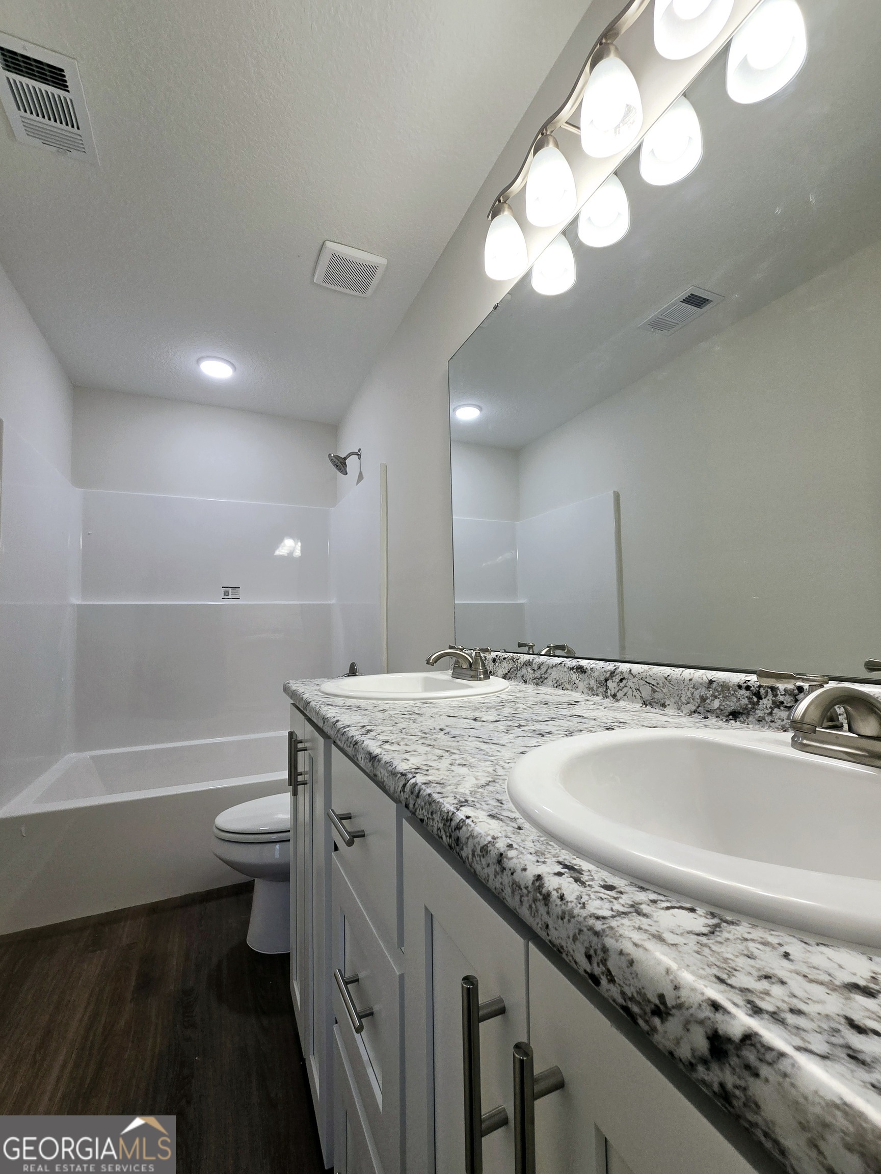 26466 Turner Road Metter, GA 30439 - Photo 15 of 39 a bathroom with a granite countertop sink a toilet and bathtub