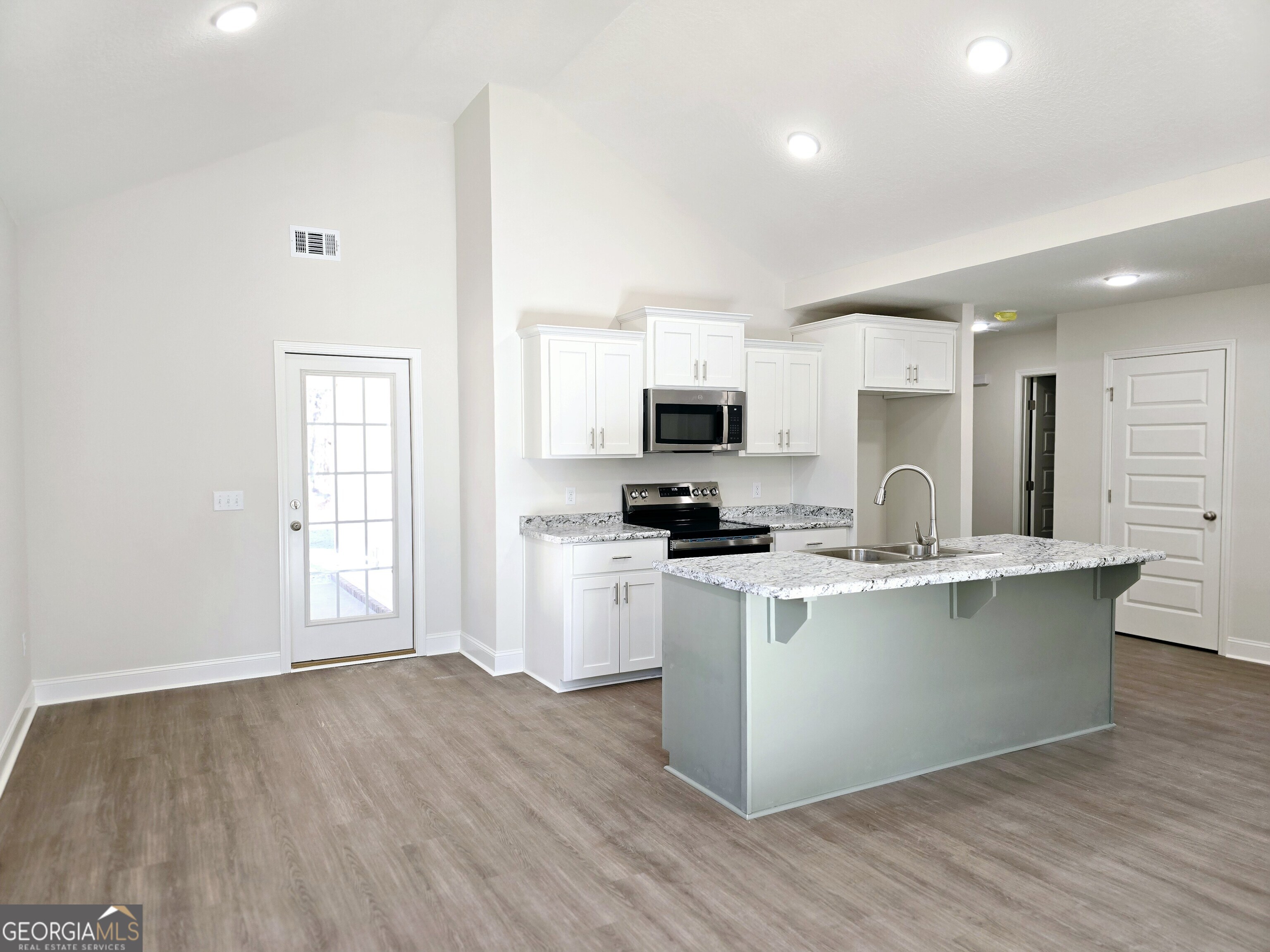26466 Turner Road Metter, GA 30439 - Photo 32 of 39 a kitchen with stainless steel appliances a white stove top oven a sink dishwasher and a refrigerator with wooden floor