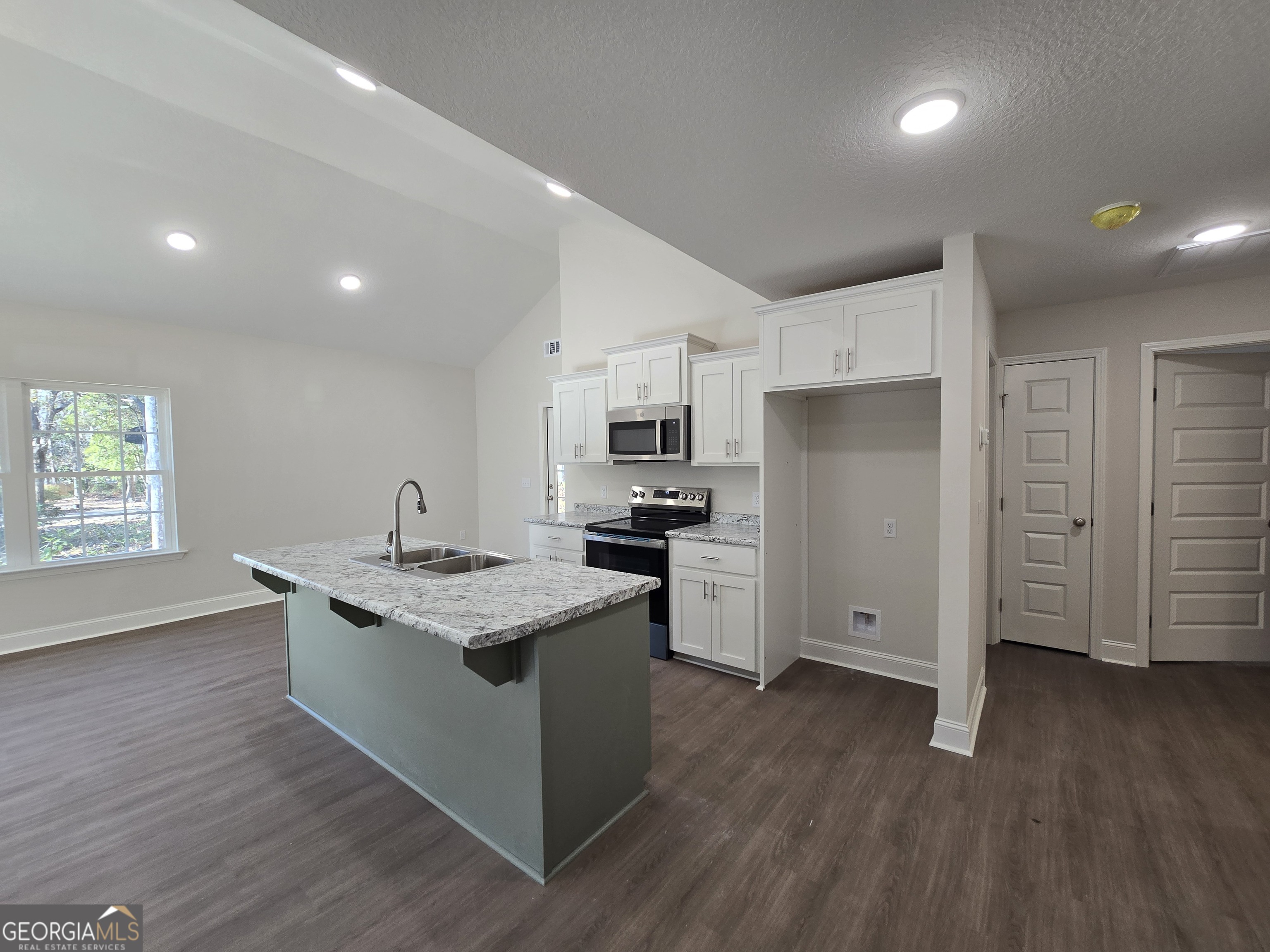26466 Turner Road Metter, GA 30439 - Photo 9 of 39 a kitchen with stainless steel appliances granite countertop a stove a sink dishwasher a refrigerator and white cabinets with wooden floor
