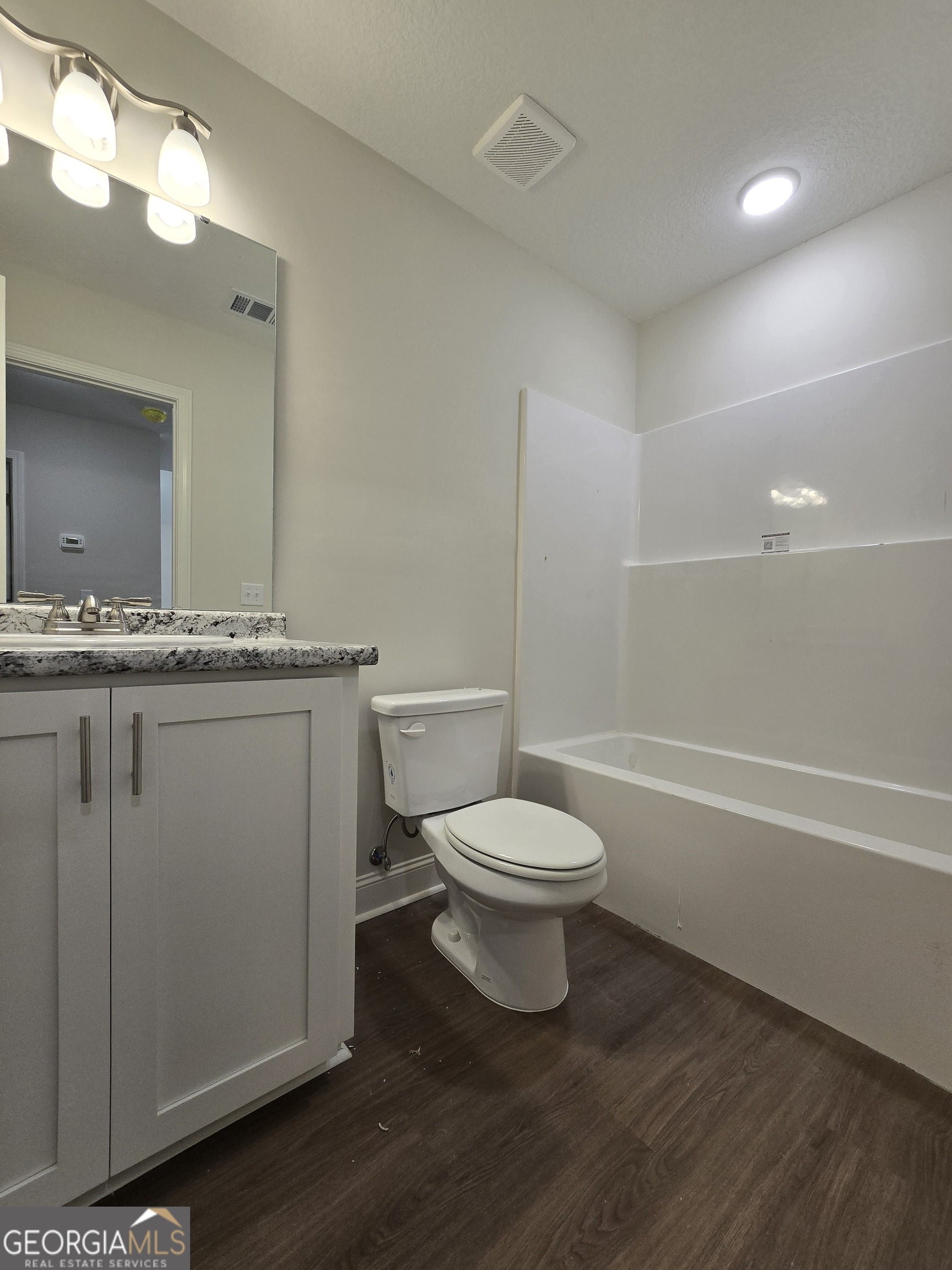 26466 Turner Road Metter, GA 30439 - Photo 10 of 39 a bathroom with a granite countertop toilet a sink and a mirror