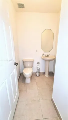 a bathroom with a toilet a sink and a mirror