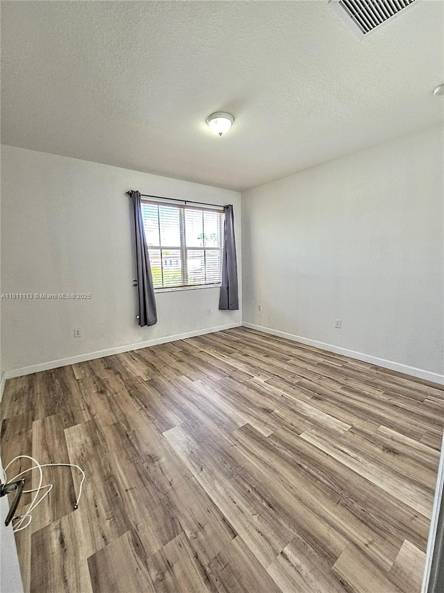 988 Southwest 154th Path Miami, FL 33194 - Photo 16 of 31 an empty room with wooden floor and windows