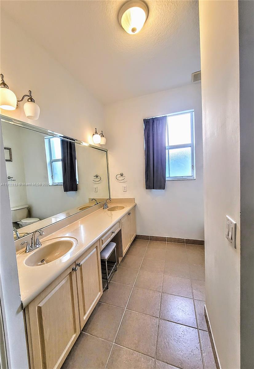 988 Southwest 154th Path Miami, FL 33194 - Photo 23 of 31 a bathroom with a sink a vanity and mirror