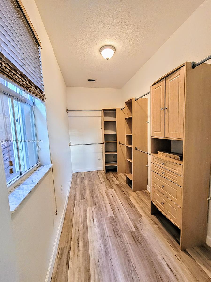 988 Southwest 154th Path Miami, FL 33194 - Photo 24 of 31 a view of walk in closet with empty racks