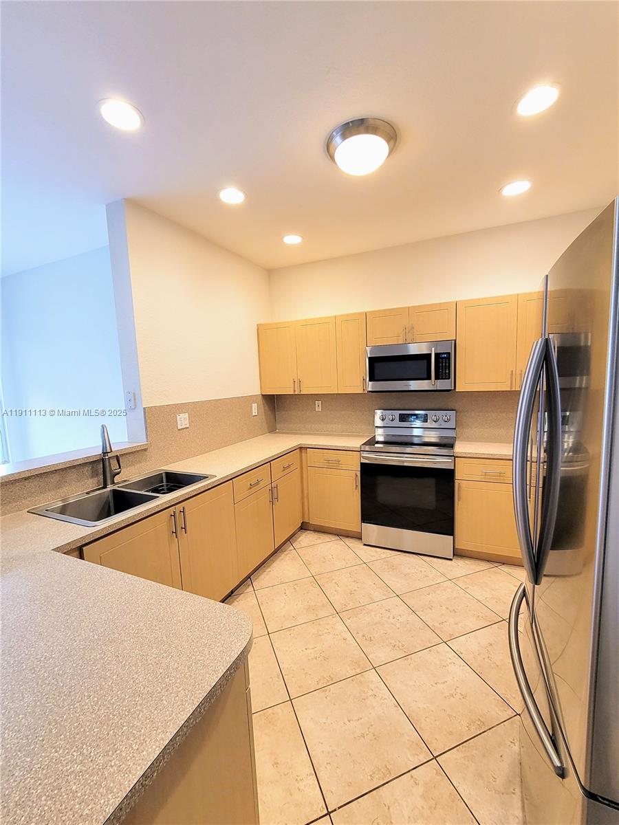 988 Southwest 154th Path Miami, FL 33194 - Photo 29 of 31 a kitchen with stainless steel appliances granite countertop a sink and white cabinets