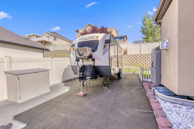 2005 Redtail Way Layton, UT 84040 - Photo 32 of 37 Paved side yard with privacy fencing, retaining wall, and built-in exterior storage unit