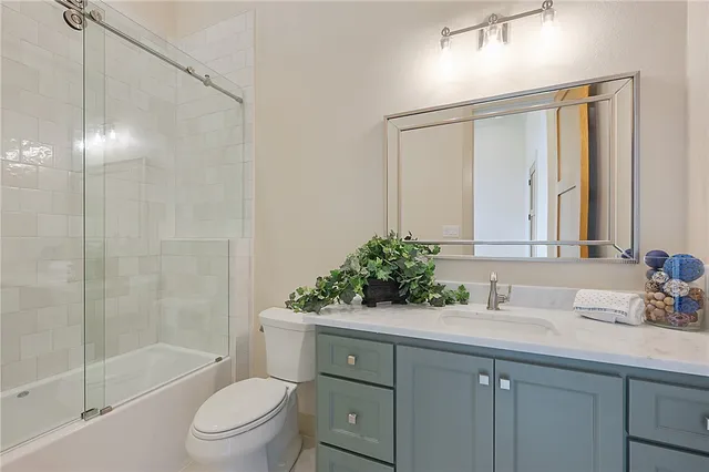 a bathroom with a toilet a sink a mirror a shower and vanity