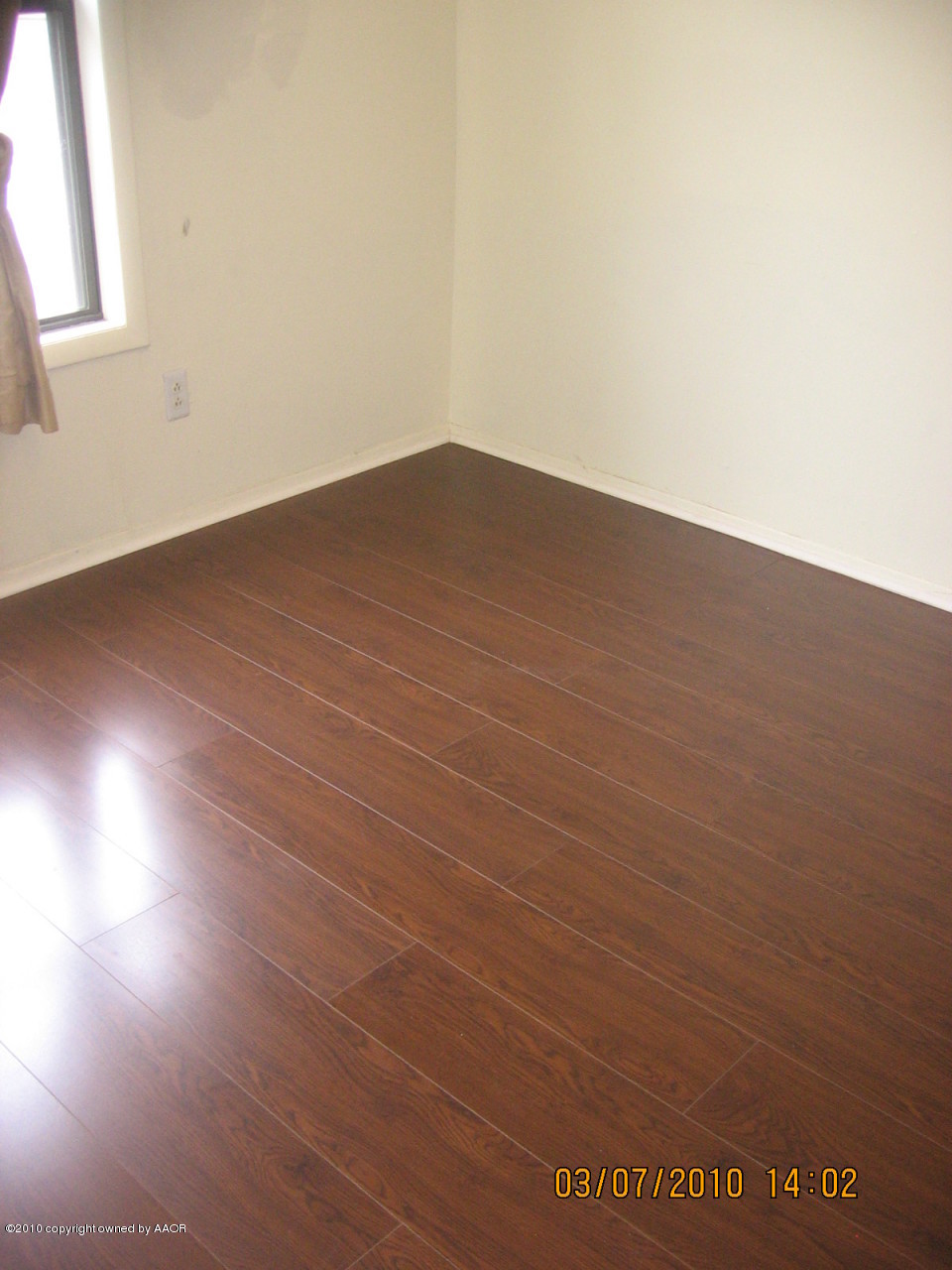 4401 Crockett Street Amarillo, TX 79110 - Photo 8 of 15 an empty room with wooden floor and windows