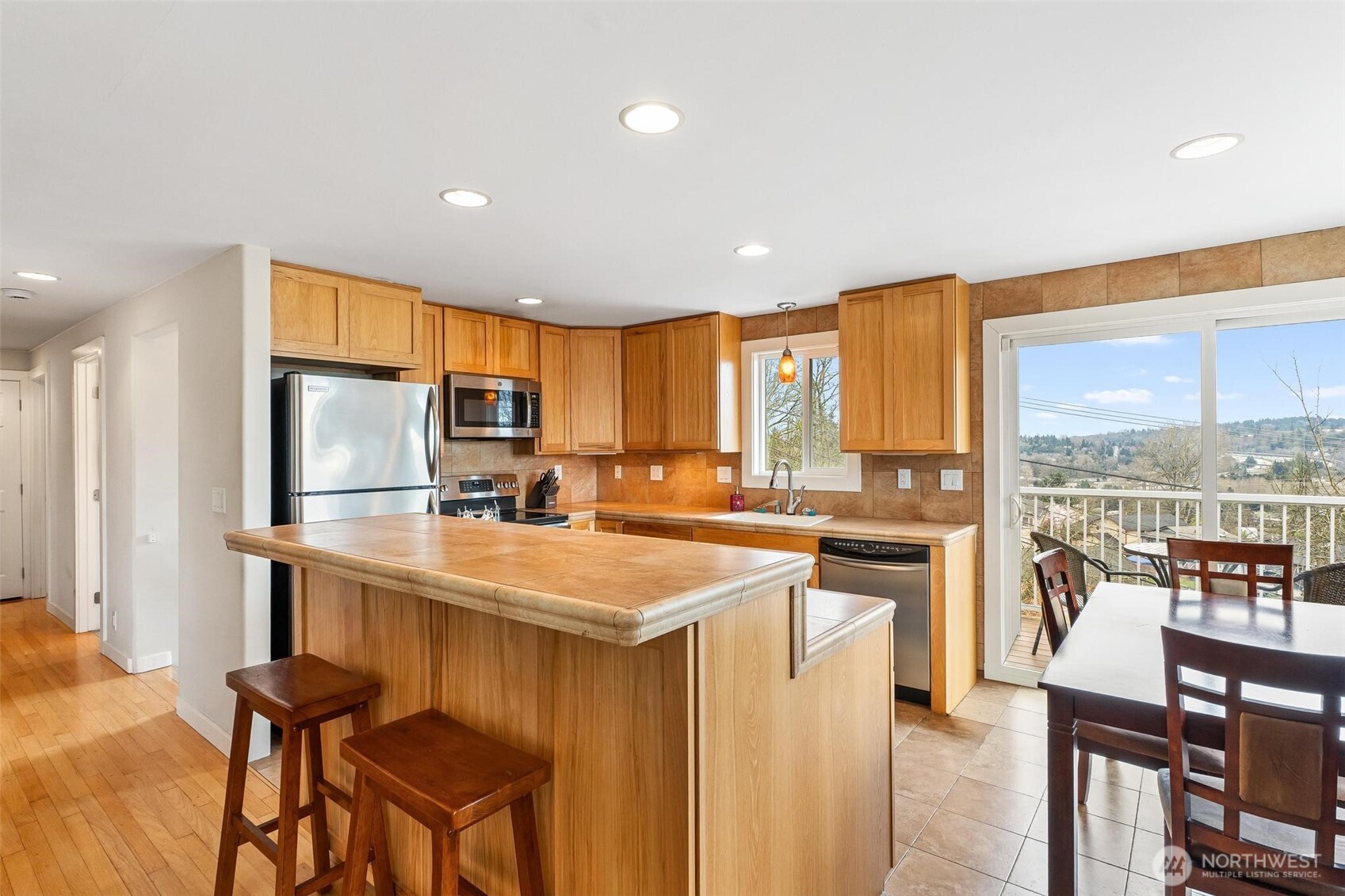 5162 South Wallace Street Seattle, WA 98178 - Photo 6 of 37 a kitchen with stainless steel appliances granite countertop a stove top oven a sink dishwasher and a refrigerator with wooden floor