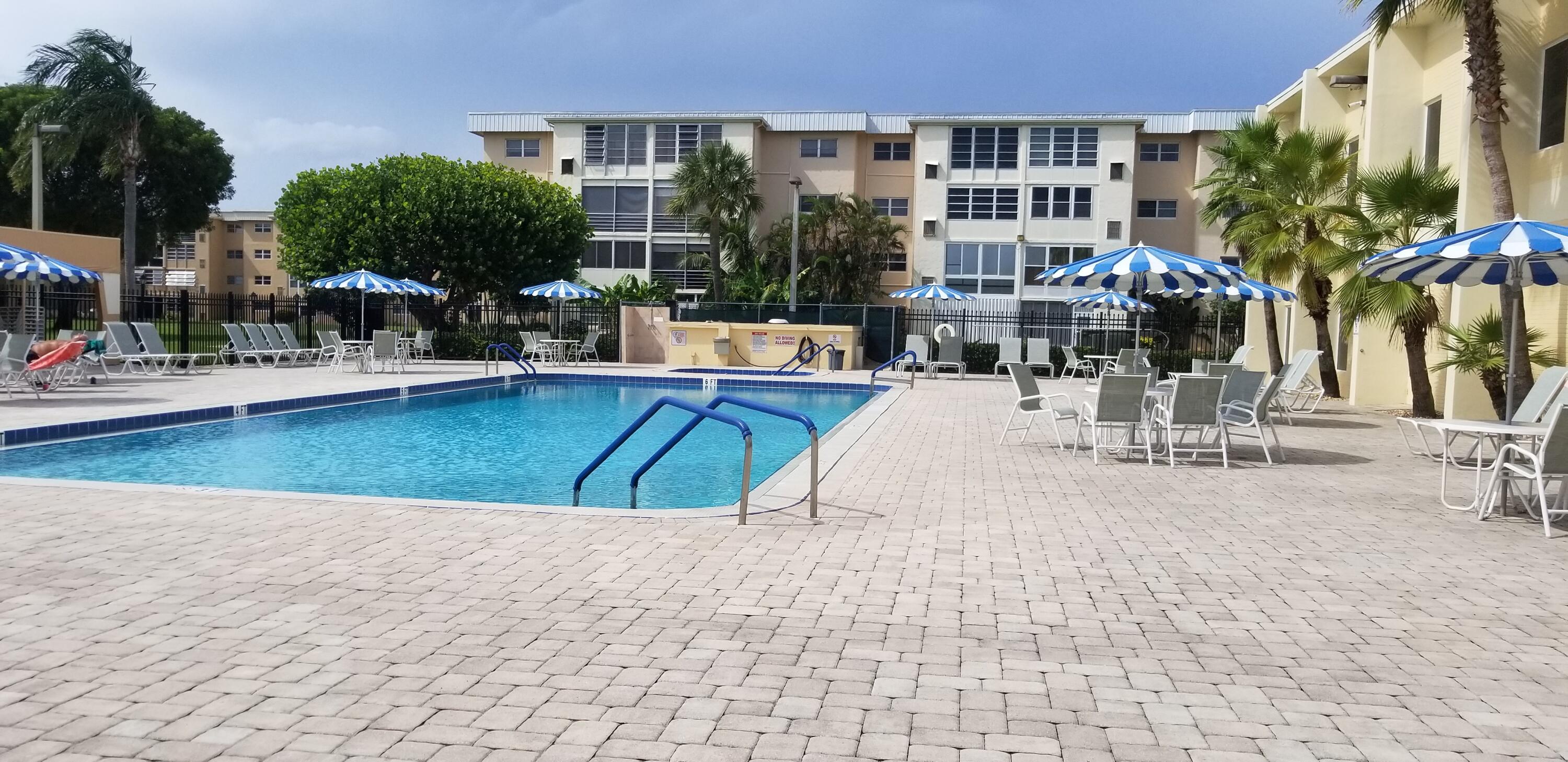 300 Northeast 26th Avenue, Unit 305 Boynton Beach, FL 33435 - Photo 28 of 54 a building with swimming pool and outdoor seating