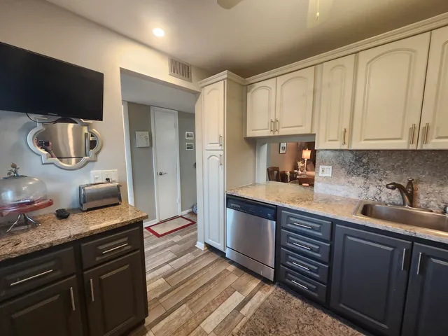 a kitchen with kitchen island granite countertop a sink and a stove top oven
